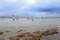 Wind surfers braving the heavy storm and rocks