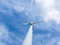 wind turbine against blue sky with white clouds Royalty Free Stock Photo