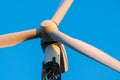 Wind turbine against a clear blue sky at a wind turbine farm at sunset. Low angle view, close-up on propeller. Sustainable energy. Royalty Free Stock Photo