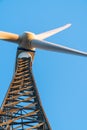 Wind turbine against a clear blue sky. Metal structure with struts and rivets at a wind turbine farm on a sunny day. Royalty Free Stock Photo