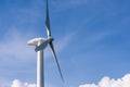 wind turbine against partly cloudy blue sky Royalty Free Stock Photo