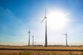 Wind turbine against sky with sun Royalty Free Stock Photo