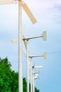 Wind turbine with blue sky and white clouds near green tree. Wind energy in eco wind farm. Green energy concept. Renewal energy. Royalty Free Stock Photo