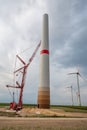 Wind turbine construction site at wind park with crane and completed wind turbines in the background during cloudy day Royalty Free Stock Photo