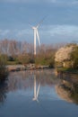 wind turbine in the field reflecting in a canal in the UK