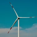 Wind turbine in front of a blue sky with white clouds Royalty Free Stock Photo