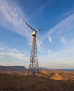 Wind turbine generating electricity in mountains at sunset Royalty Free Stock Photo