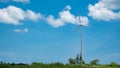 Wind turbine over the blue sky and clouds. Royalty Free Stock Photo