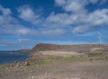 Wind turbine power plant at rocky atlantic coast in the north west of Gran Canaria with sea and cliffs, blue sky, white Royalty Free Stock Photo