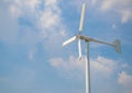 Wind turbine producing alternative energy on cloudy sky background Royalty Free Stock Photo