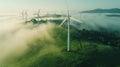 Wind turbine renewable energy windfarm with windmills aerial view with fog in green field