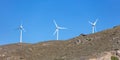 Wind turbine on a rocky hill, clear blue sky background, sunny day. Renewable power energy Royalty Free Stock Photo