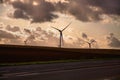 Wind turbine running at the edge of a country road Royalty Free Stock Photo