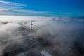Wind turbine Sitting above heavy fog,mist on a early morning sunrise in south wales uk. Wind farm generating green Royalty Free Stock Photo