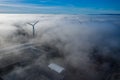 Wind turbine Sitting above heavy fog,mist on a early morning sunrise in south wales uk. Wind farm generating green Royalty Free Stock Photo