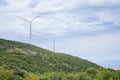 Wind turbine on the top of the mountatin with sea in background Royalty Free Stock Photo