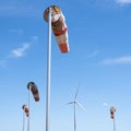 Wind turbine and windbag as silhouette against blue sky Royalty Free Stock Photo