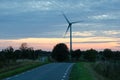 Wind turbine by a winding road at late evening Royalty Free Stock Photo