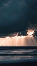 Wind turbines in the distance as a storm clears with sunlight breaking through dark clouds Royalty Free Stock Photo