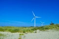 Wind turbines in dune landscape at North Sea by blue sky