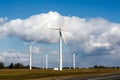 Wind turbines on a farm field against a bright blue sky with white clouds. Clean wind power Royalty Free Stock Photo