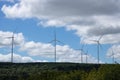 Wind Turbines farm in the hill a background of forest, blue sky and cloud Royalty Free Stock Photo