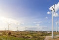 Wind turbines farm on mountanis landscape against blue sky with clouds background,Windmills for electric power ecology concept Royalty Free Stock Photo