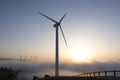 Wind turbines in the fog. Wind farm at sunset and sun above the clouds Royalty Free Stock Photo