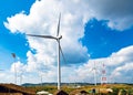 Wind turbines Geneating Clean Energy and Electricity in Blue Sky with High Electricity Post in Thailand Royalty Free Stock Photo