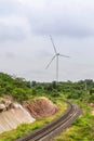 Wind turbines generating electricity behind railroad tracks Royalty Free Stock Photo