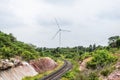 Wind turbines generating electricity behind railroad tracks Royalty Free Stock Photo