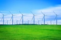 Wind turbines generating electricity on green meadow Royalty Free Stock Photo