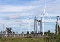 Wind turbines generating electricity with high voltage electrical power pylon substation Royalty Free Stock Photo