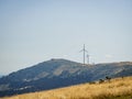 Wind turbines on a golden hill during summer