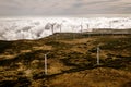 Wind turbines for green energy in a windy place high in the mountains above the clouds. Royalty Free Stock Photo