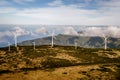 Wind turbines for green energy in a windy place high in the mountains above the clouds. Royalty Free Stock Photo