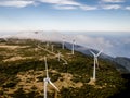 Wind turbines for green energy in a windy place high in the mountains above the clouds. Royalty Free Stock Photo