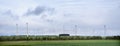 Wind turbines and green fields under blue cloudy sky in german eifel Royalty Free Stock Photo