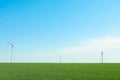 Wind turbines in a green grass field, space for text Royalty Free Stock Photo