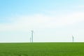 Wind turbines in a green grass field, space for text Royalty Free Stock Photo