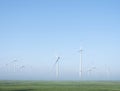 Wind turbines in green meadow near aurich in ostfriesland on misty morning in august