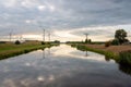 Wind turbines and high voltage pylons reflected in the water