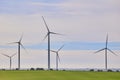 Wind turbines with landscape of agricultural fields under blue sky Royalty Free Stock Photo