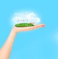 Wind turbines on meadow holds in womans hand against blue sky Royalty Free Stock Photo