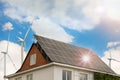 Wind turbines near house with solar panels on roof. Alternative energy source Royalty Free Stock Photo