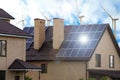 Wind turbines near house with installed solar panels. Alternative energy source Royalty Free Stock Photo