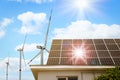 Wind turbines near house with solar panels on roof. Alternative energy source Royalty Free Stock Photo