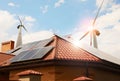 Wind turbines near house with solar panels on roof. Alternative energy source Royalty Free Stock Photo