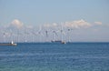 Wind turbines park and cargo ship passes in international water Royalty Free Stock Photo