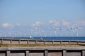 Wind turbines park and cargo ship passes in international water Royalty Free Stock Photo